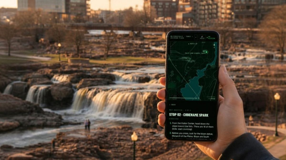 A hand holds a phone showing the Falls Sentinel tactical map, with the falls of the Big Sioux River behind at golden hour