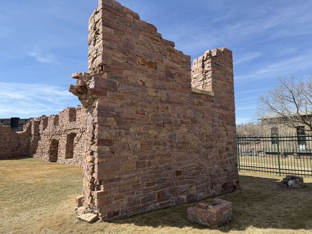A ruined pink quartzite wall of the old Queen Bee Mill against a blue sky
